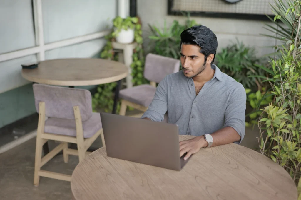 Person sitting at a table on their laptop