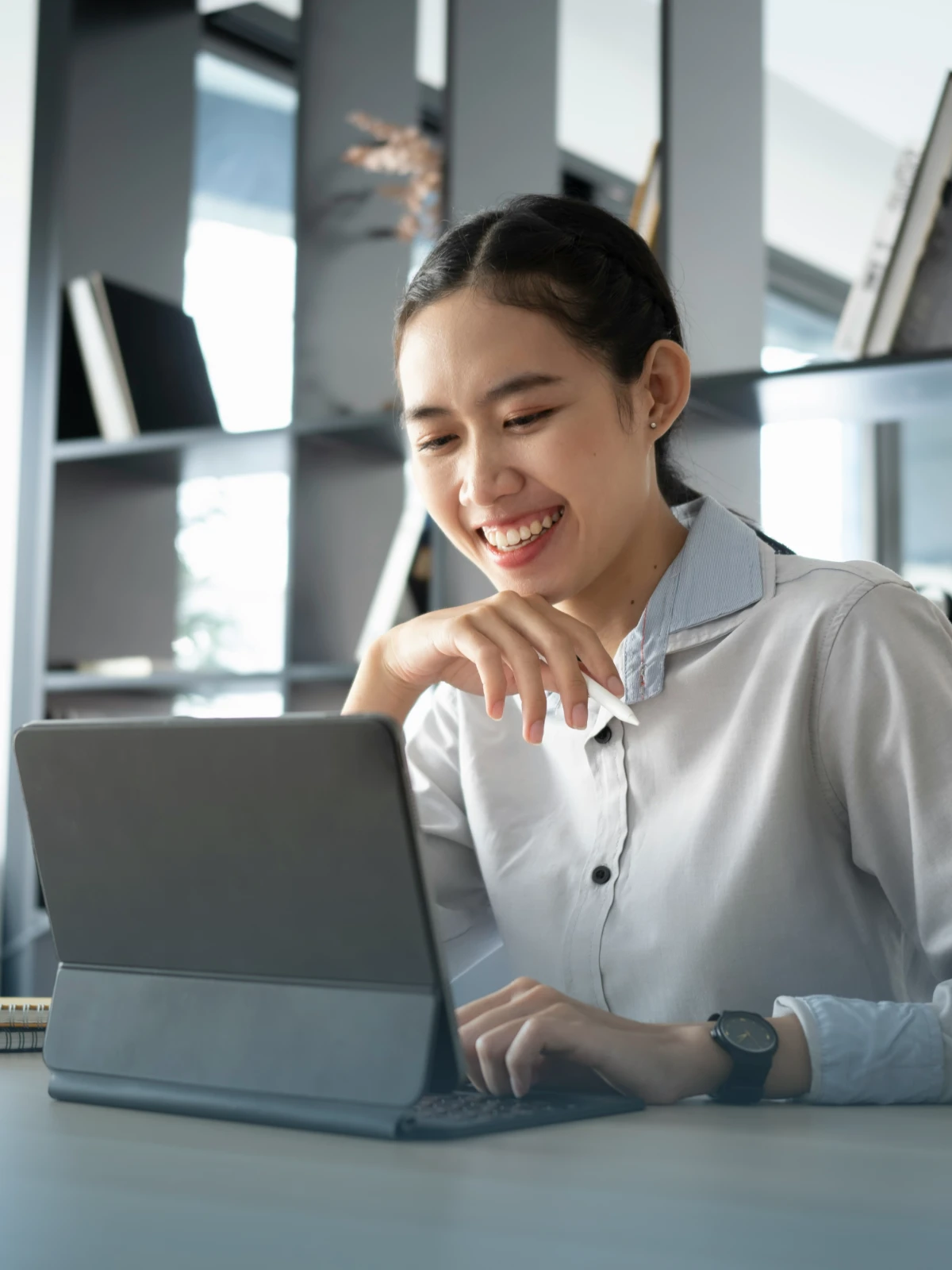 Smiling woman working on a laptop.