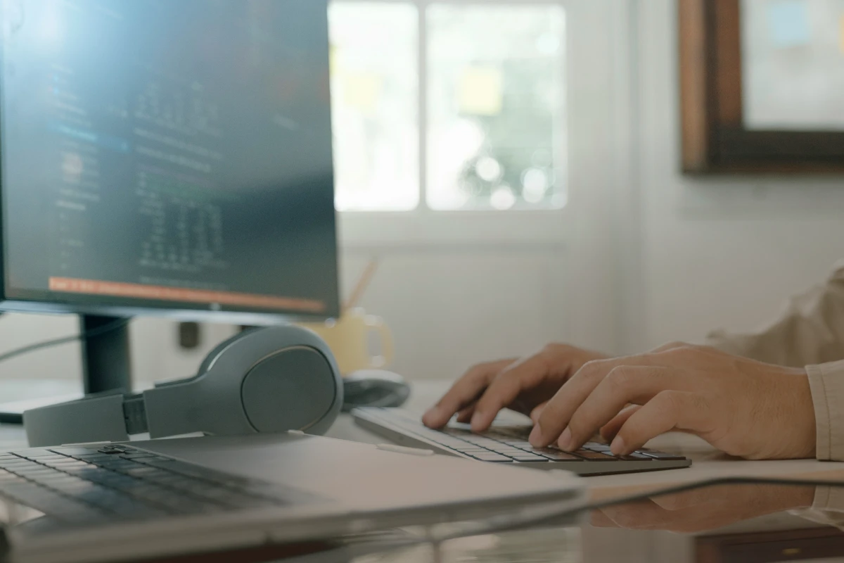 Close up of man's hands working on a desktop keyboard.