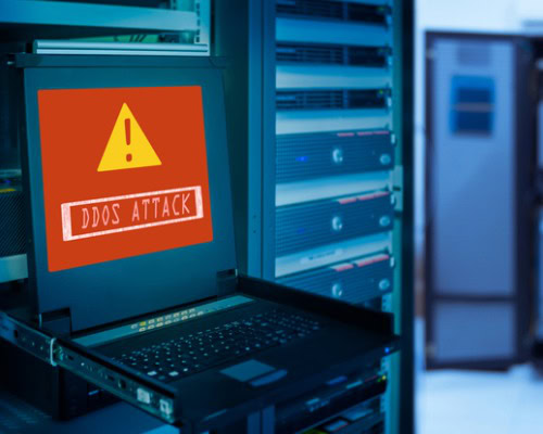 DDoS ATTACK alert on a laptop in a server room