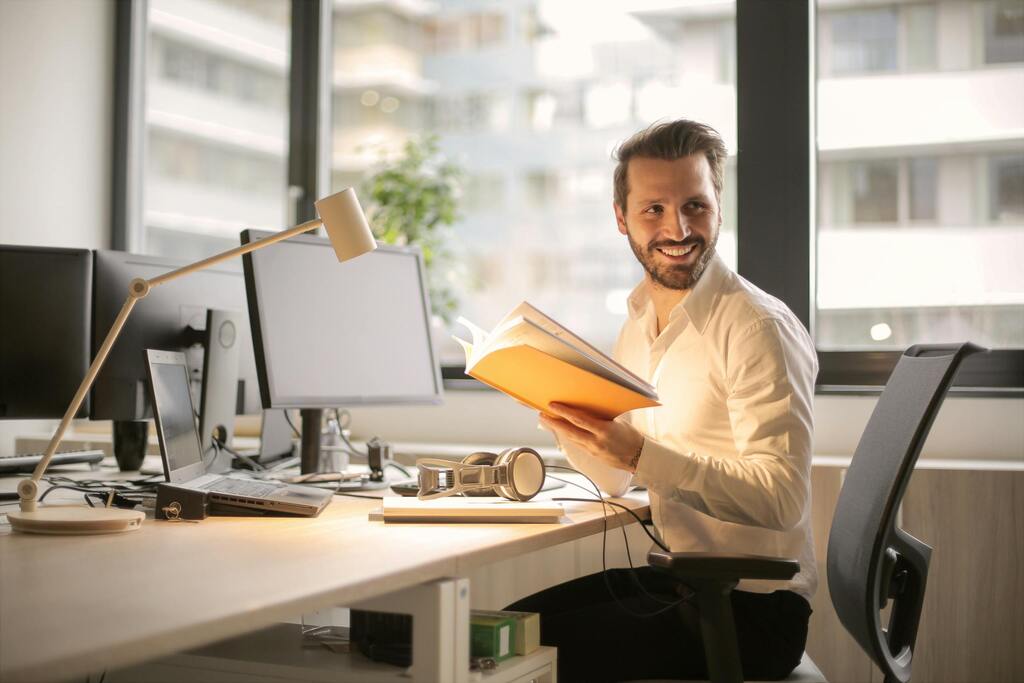 Photo of Man Holding a Book Happy to be a VPS Hosting Reseller