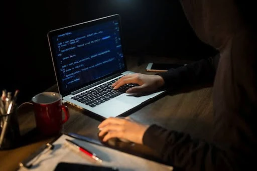A person coding on a laptop