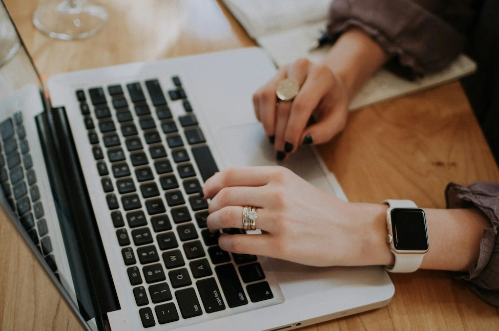 A WordPress user's hands type on a laptop computer to disable automatic updates