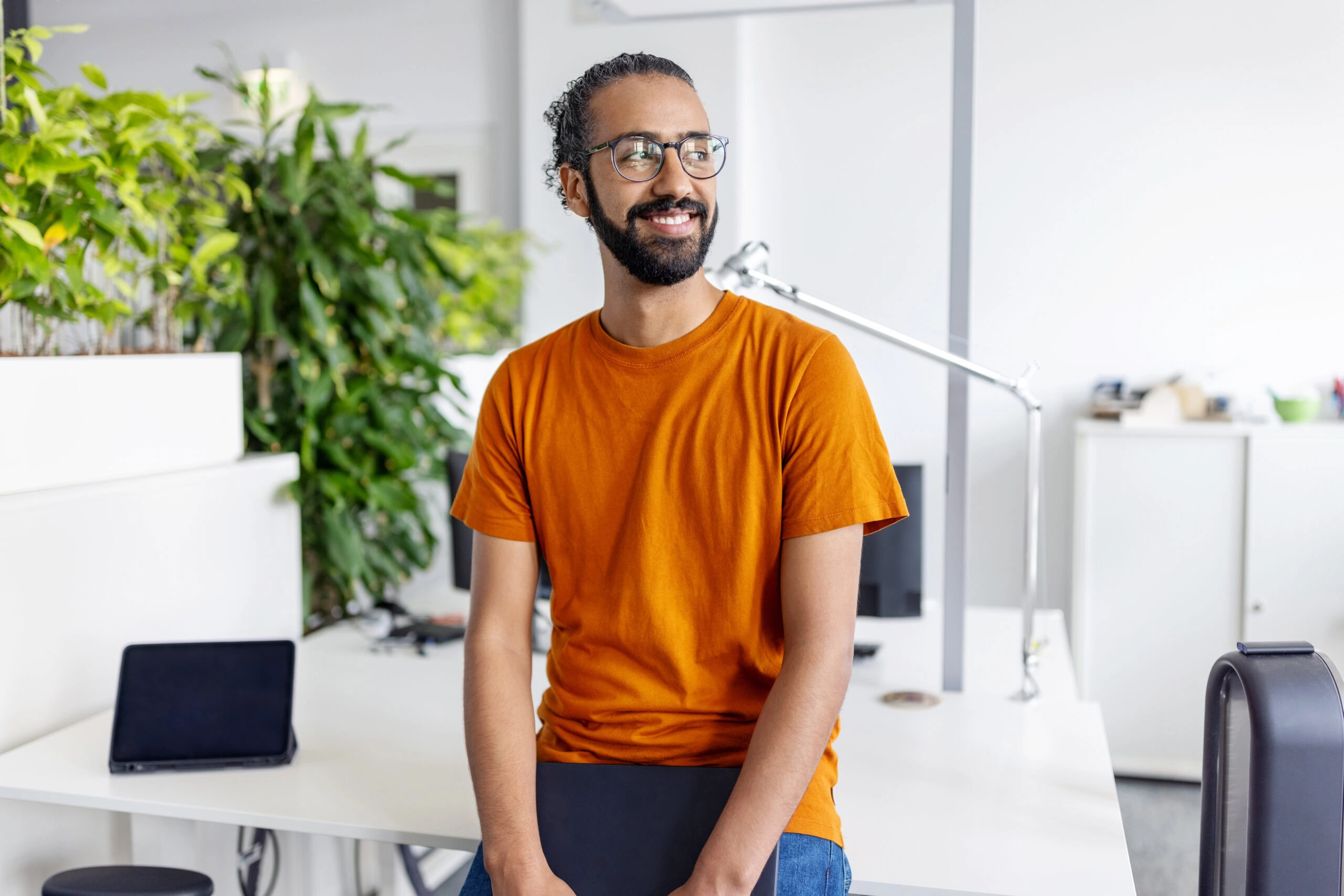 Portrait of a smiling businessman sitting at creative office