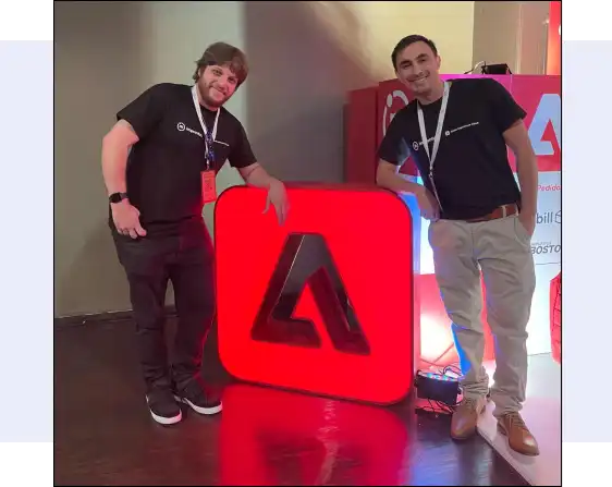 Improntus staff posing with Adobe logo