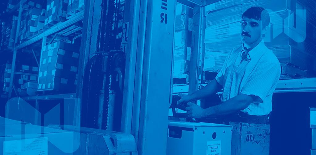 A man in a warehouse surrounded by packages.
