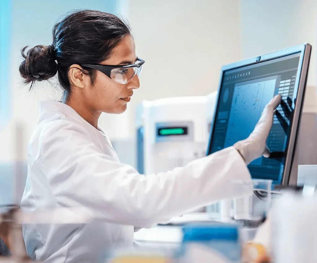Woman doctor faces a computer screen and interacts with an application that's hosted with a HIPAA compliant provider.