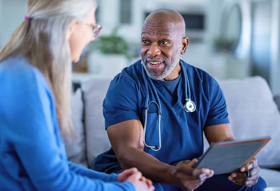 Doctor holding a chart and speaking with patient.